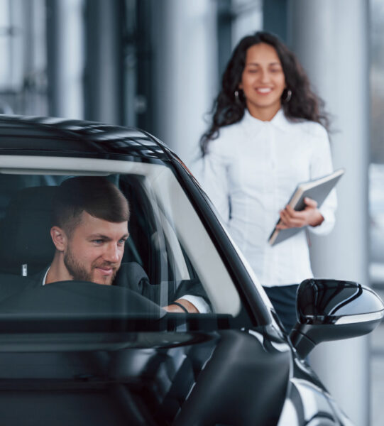 Everyone is satisfied. Male customer and modern businesswoman in the automobile saloon Everyone is satisfied. Male customer and modern businesswoman in the automobile saloon.